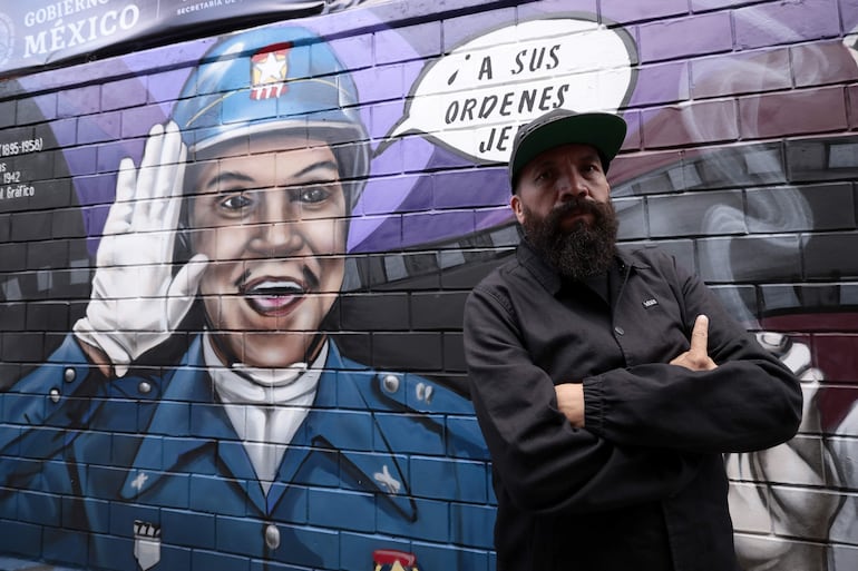 El artista urbano Yuka posa junto a su mural dedicado al actor mexicano Mario Moreno "Cantinflas".