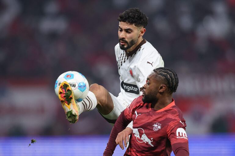 St Pauli's German forward #26 Elias Saad (L) and Leipzig's German midfielder #17 Ridle Baku vie for the ball during the German first division Bundesliga football match RB Leipzig vs St Pauli in Leipzig, eastern Germany on February 9, 2025. (Photo by Ronny HARTMANN / AFP) / DFL REGULATIONS PROHIBIT ANY USE OF PHOTOGRAPHS AS IMAGE SEQUENCES AND/OR QUASI-VIDEO