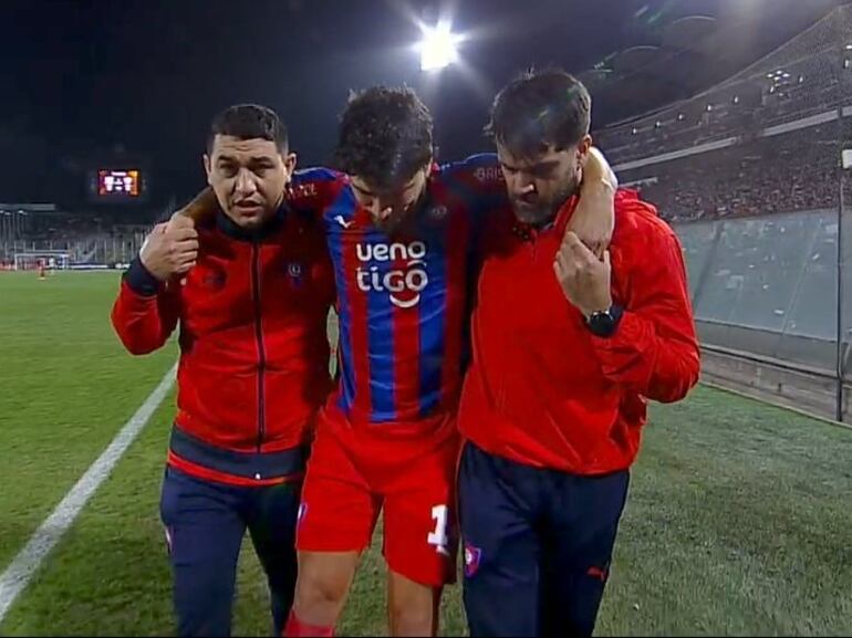 El paraguayo Bruno Valdez, jugador de Cerro Porteño, abandona el campo de juego asistido por los médicos en el partido ante Colo Colo por la Copa Libertadores 2024 en el estadio Monumental de Santiago, en Chile.