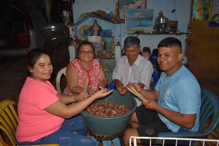 Don Enrique junto a su esposa doña Arminda y dos de sus siete hijos preparando el asadito.