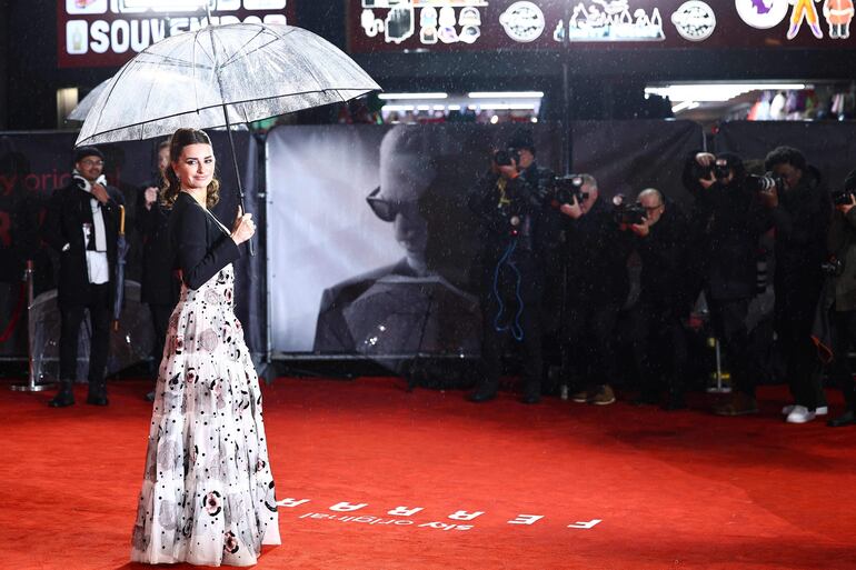 La actriz española Penélope Cruz llegó con un paraguas a la alfombra roja de "Ferrari", en Londres. (HENRY NICHOLLS/AFP)