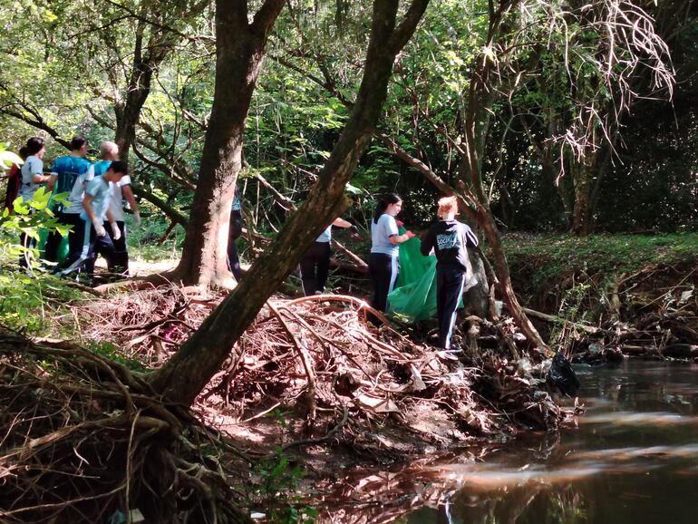 Pobladores de Encarnación se unen para limpiar el cauce del arroyo Poti’y, que está contaminado con residuos urbanos.