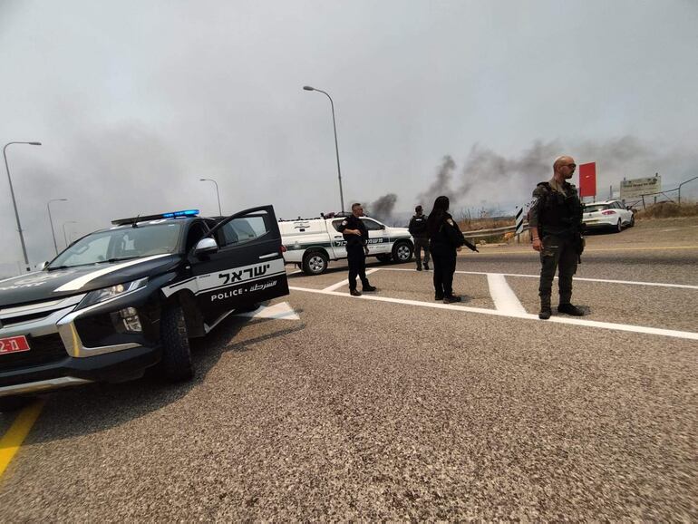 Agentes de la policía israelí analizan los restos de cohetes.