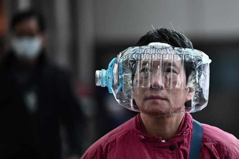 Una persona lleva una máscar hecha con una botella de plástico para cubrirse la cara, como medida preventiva tras un brote de virus que comenzó en la ciudad china de Wuhan.