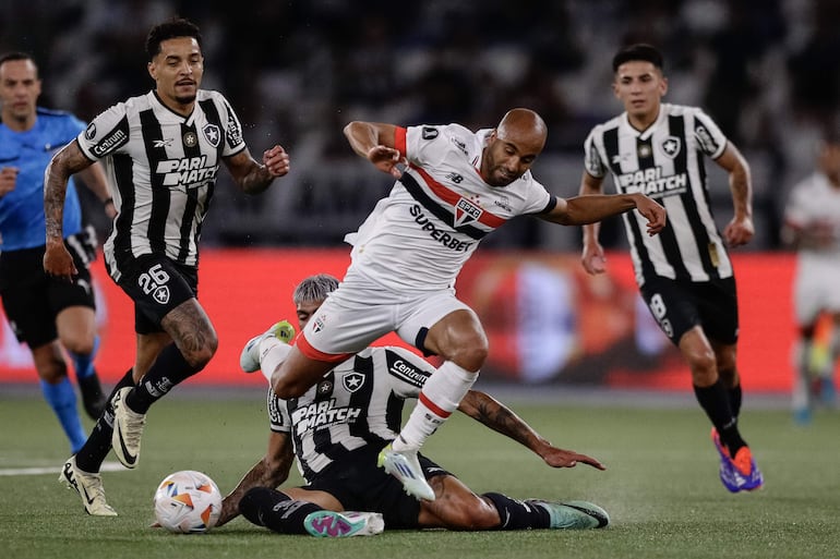 Alexander Barboza (abajo) de Botafogo disputa un balón con Lucas Moura (c) de Sao Paulo este miércoles, en el partido de ida de cuartos de final de la Copa Libertadores entre Botafogo y Sao Paulo en el estadio Olímpico Nilton Santos en Río de Janeiro (Brasil). 