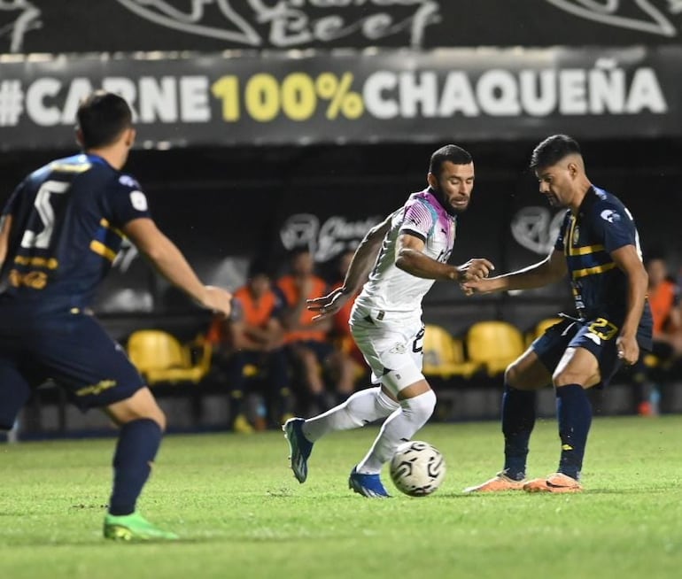 Antonio Bareiro trata de llevarse el balón ante la presencia de dos jugadores de Sportivo Trinidense