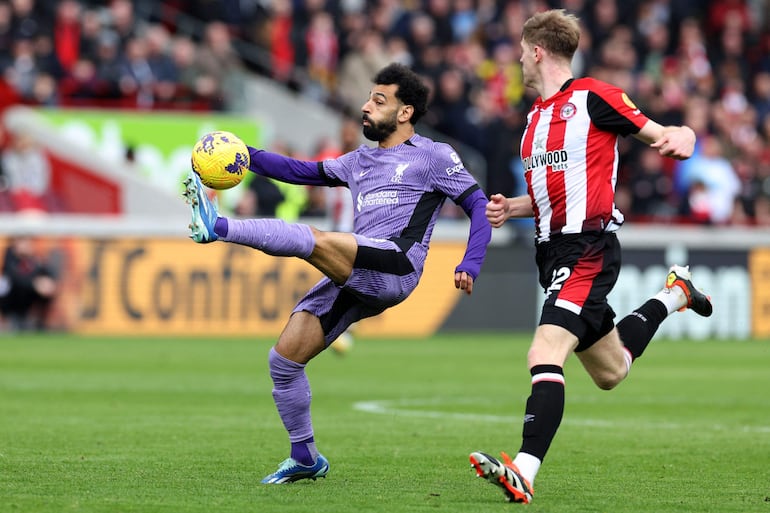 Liverpool's Egyptian striker #11 Mohamed Salah controls the ball during the English Premier League football match between Brentford and Liverpool at the Gtech Community Stadium in London on February 17, 2024. (Photo by Adrian DENNIS / AFP) / RESTRICTED TO EDITORIAL USE. No use with unauthorized audio, video, data, fixture lists, club/league logos or 'live' services. Online in-match use limited to 120 images. An additional 40 images may be used in extra time. No video emulation. Social media in-match use limited to 120 images. An additional 40 images may be used in extra time. No use in betting publications, games or single club/league/player publications. / 