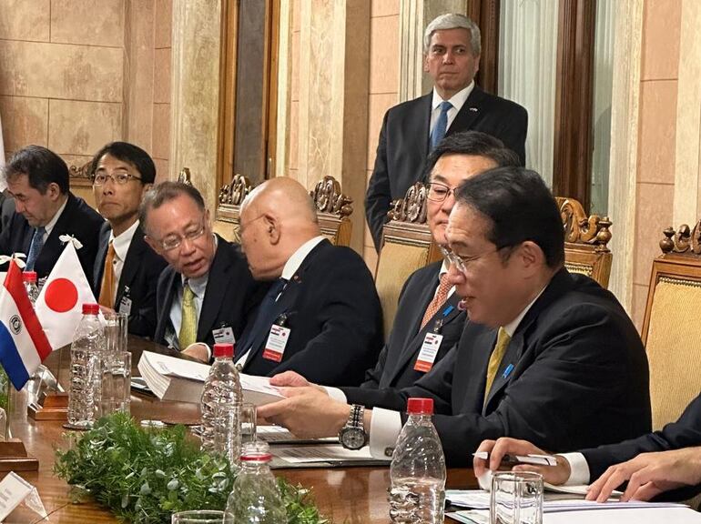 El primer ministro del Japón, Kishida Fumio, mirando la tapa del informe del Senacsa, que le fue presentado en Palacio de López.