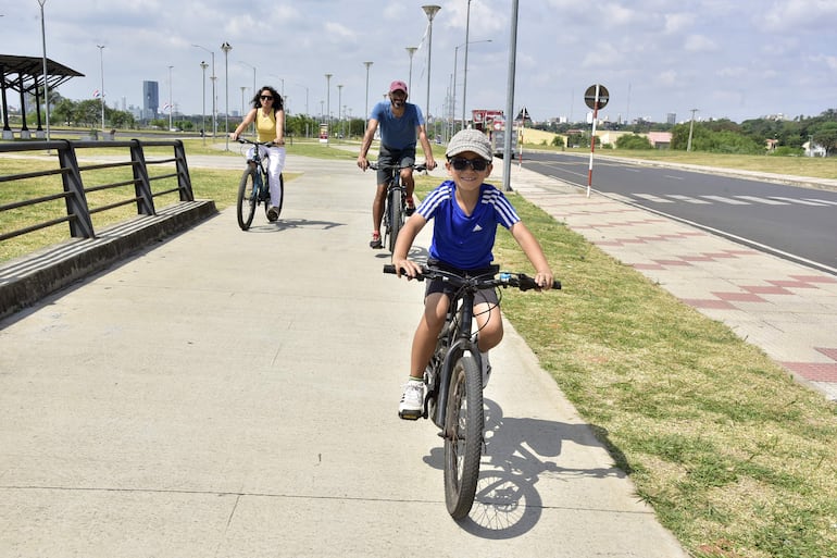 Una familia pasea en bicicleta por la Costanera de Asunción, ahora que el aire recuperó su calidad, según el Mades.