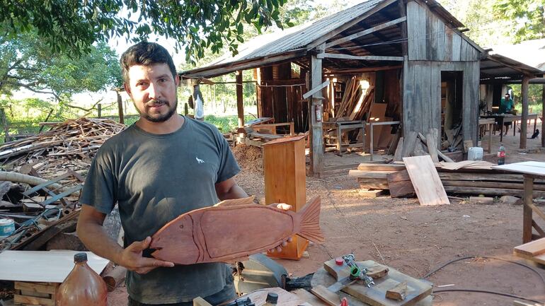 Emprendedor muestra con orgullo su trabajo en madera