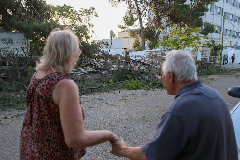 Residentes observan hoy los daños causados por el temporal del pasado sábado, en Bahía Blanca, provincia de Buenos Aires (Argentina). El temporal de lluvia y fuertes vientos que azotó a la capital de Argentina y a diversas ciudades de la provincia de Buenos Aires ha provocado la muerte de 14 personas y dejó severos destrozos, una catástrofe que ha movido al presidente argentino, Javier Milei, a viajar este domingo a la zona más afectada por la emergencia. EFE/Juan Macri