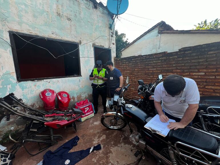 Intervinientes de la Policía Nacional y la Fiscalía anotan datos de las motocicletas encontradas en el "aguantadero" de Villa Casu de San Lorenzo.