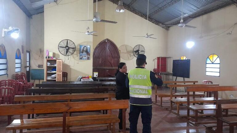 Un policía de la Comisaría 23 Central de Ypané toma nota de los objetos robados del interior de la capilla San Roque.