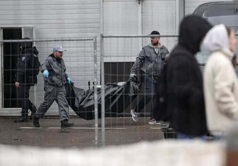 El personal médico transporta los cuerpos de las víctimas a vehículos en la sala de conciertos del Crocus City Hall tras un ataque terrorista en Krasnogorsk, en las afueras de Moscú ayer.