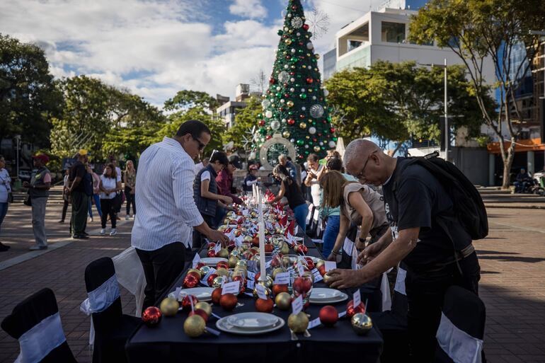 AME3073. CARACAS (VENEZUELA), 08/12/2023.- Un grupo de personas decora una mesa con motivos navideños como parte de una manifestación hoy, en Caracas (Venezuela). Decenas de venezolanos se manifestaron este viernes en Caracas para pedir a las autoridades la liberación, antes de Navidad, de cerca de 310 detenidos que figuran en la lista de "presos políticos" que existen en el país, según registros de la organización no gubernamental Justicia, Encuentro y Perdón (JEP). EFE/ Miguel Gutiérrez
