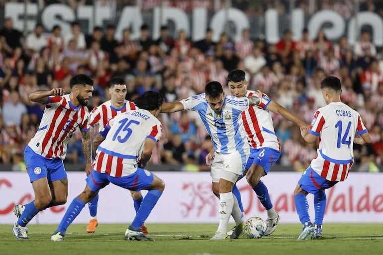 Los jugadores de la selección de Paraguay rodean a Lautaro Martínez, futbolista de Argentina, en el partido por la fecha 11 de las Eliminatorias Sudamericanas 2026 en el estadio Defensores del Chaco, en Asunción, Paraguay.