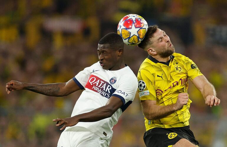 TOPSHOT - Paris Saint-Germain's Portuguese defender #02 Nuno Mendes (L) and Dortmund's German forward #14 Niclas Fuellkrug vie for the ball during the UEFA Champions League semi-final first leg football match between Borussia Dortmund and Paris Saint-Germain (PSG) on May 1, 2024 in Dortmund. (Photo by Odd ANDERSEN / AFP)