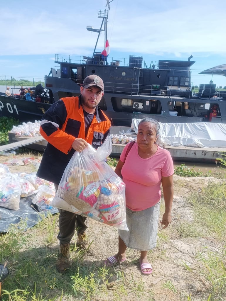 Un funcionario de la SEN entrega el kit de alimento a una mujer Ishir de la comunidad de Esperanza, en la mañana de hoy.