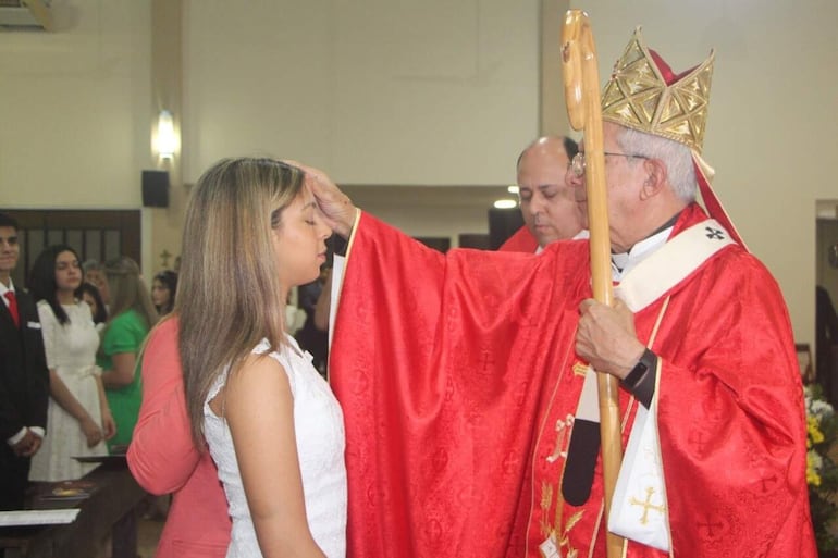 El obispo Adalberto Martínez unge la frente de una joven para que sea consagrada a la Iglesia.
