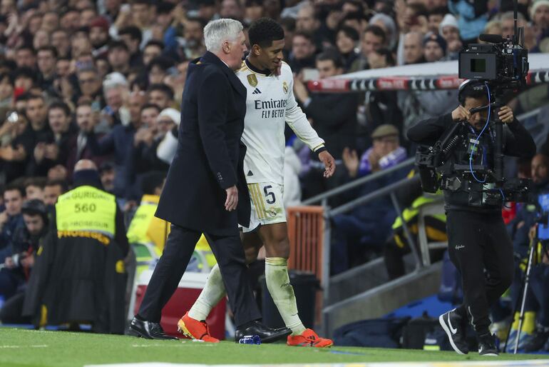 El centrocampista inglés del Real Madrid Jude Bellingham junto al entrenador Carlo Ancelotti (i), durante el partido de la jornada 17 de Liga en Primera División que Real Madrid y Villarreal CF disputan hoy domingo en el estadio Santiago Bernabéu. 