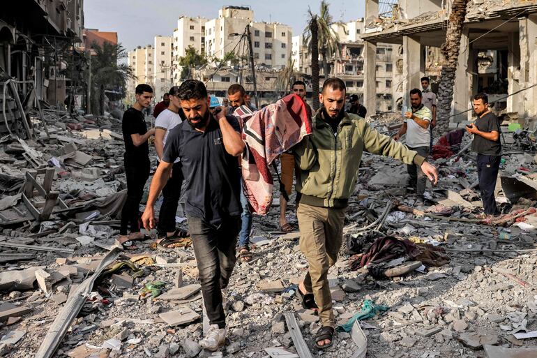 Voluntarios retiran el cuerpo de una persona fallecida en un bombardeo israelí en la Ciudad de Gaza, este miércoles.