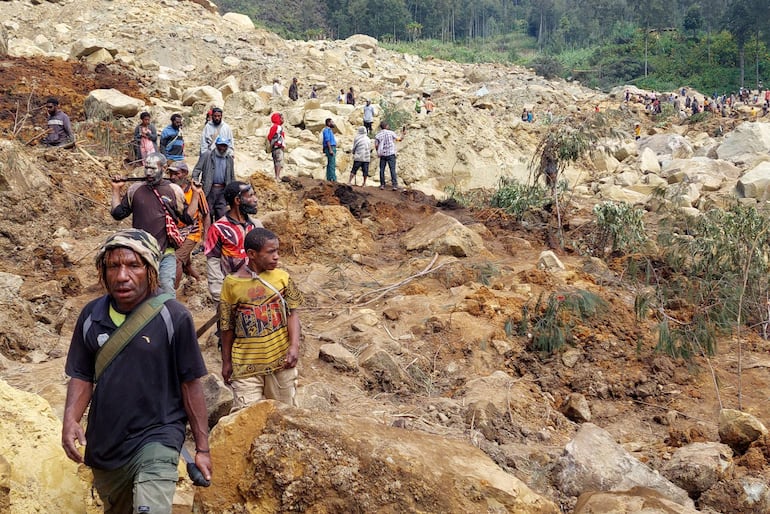 Personas reunidas en el sitio del deslizamiento de tierra en la localidad de Mulitaka, en Papúa Nueva Guinea, el domingo.