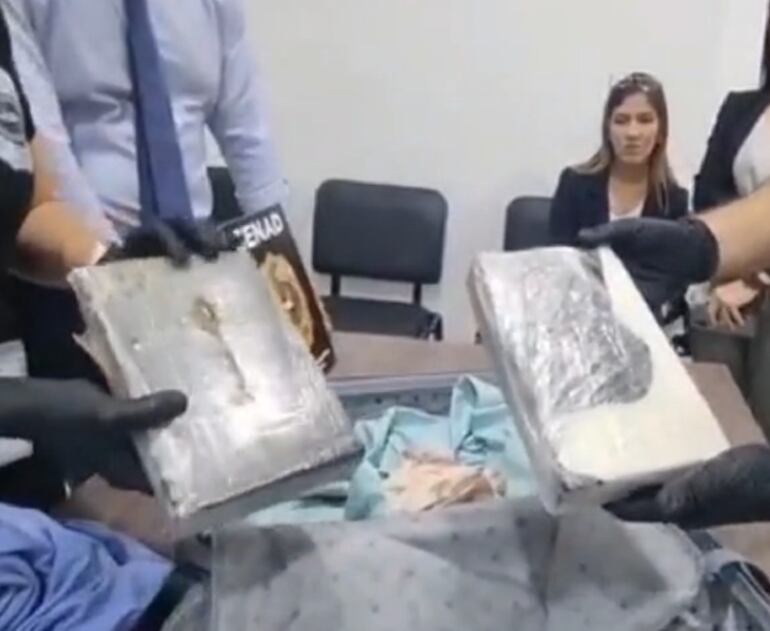 La detenida Eliana Beatriz Cardozo observó cómo inspeccionaron su maleta y hallaron la droga en octubre último. (captura de pantalla).