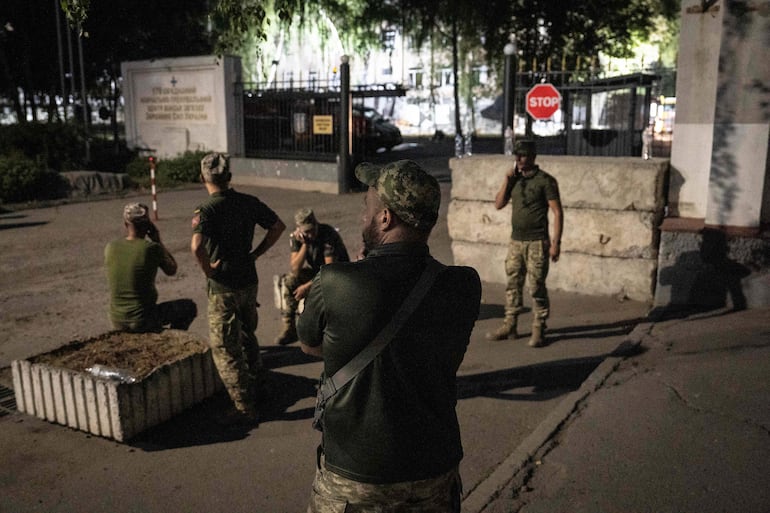 Soldados ucranianos fuera de una academia militar que recibió impactos de misiles rusos el martes en Poltava, en el este de Ucrania.