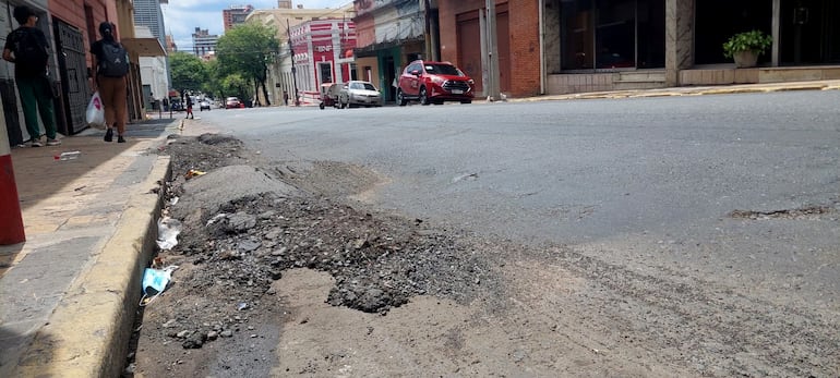 Paradas de colectivo sobre Cerro Corá frente a calles destruídas.