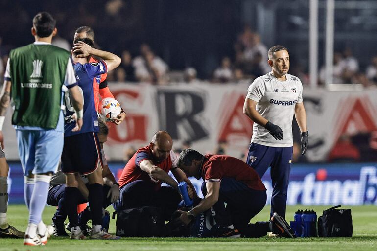 Juan Izquierdo, jugador de Nacional, es asistido por los médicos tras desplomarse en el campo de juego en pleno partido frente a Sao Paulo por los octavos de final de la Copa Libertadores 2024 en el estadio Morumbí, en Sao Paulo, Brasil.