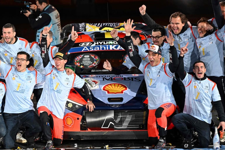 Thierry Neuville (36 años) y Martijn Wydaeghe (32) celebran el campeonato frente al Hyundai i20 N Rally2, en compañía de los integrantes del equipo surcoreano.