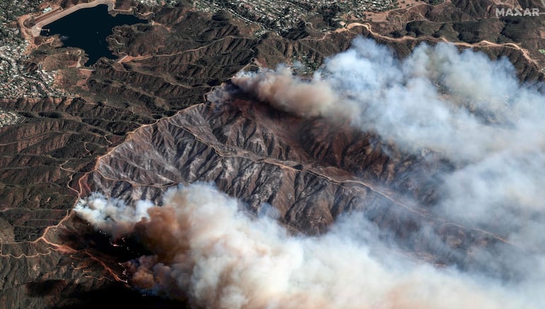 Esta imagen satelital tomada y publicada por Maxar Technologies el 11 de enero de 2025 muestra una vista general del incendio de Palisades mientras continúa ardiendo en las montañas al norte de Santa Mónica, California, con el embalse de Encino visible a la distancia (izquierda). 