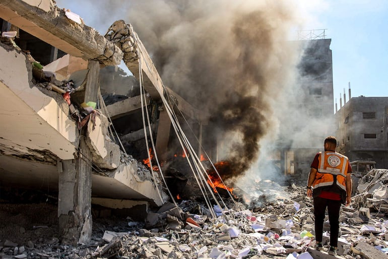 Un rescatista observa las llamas en el sitio de un bombardeo israeí en la Ciudad de Gaza, el pasado 3 de septiembre.