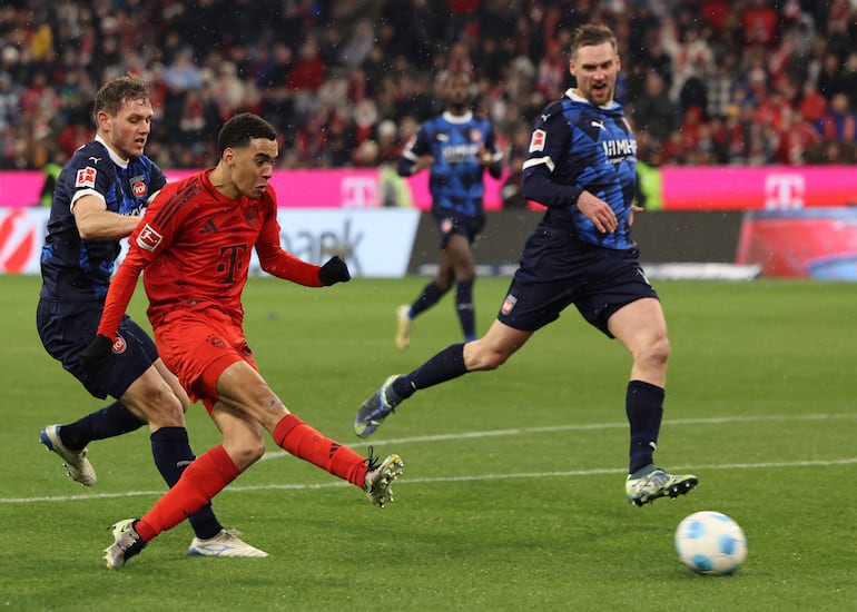 Bayern Munich's German midfielder #42 Jamal Musiala shoots to score the 4-2 during the German first division Bundesliga football match between FC Bayern Munich and Heidenheim in Munich, southern Germany, on December 7, 2024. (Photo by Alexandra BEIER / AFP) / DFL REGULATIONS PROHIBIT ANY USE OF PHOTOGRAPHS AS IMAGE SEQUENCES AND/OR QUASI-VIDEO