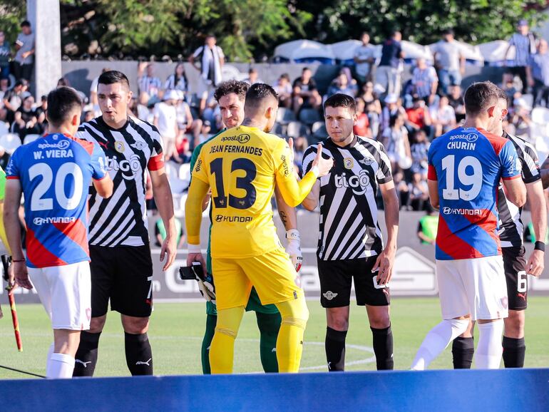 Los futbolistas de Cerro Porteño y Libertad se saludan previo al partido por el fútbol paraguayo en el estadio La Huerta, en Asunción.