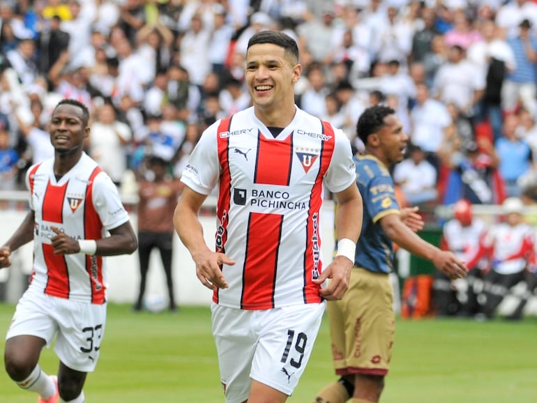 El paraguayo Alex Arce (d), futbolista de la Liga de Quito, festeja un gol en el partido frente al Deportivo Cuenca por la última fecha de la Segunda Fase de la LigaPro de Ecuador en el estadio Rodrigo Paz Delgado, en Quito.