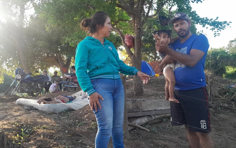 Doña Mariela Arevalos (26), con sus hijos y sus pertenencias a un costado de la propiedad fiscal, de donde fue desalojada por otro grupo de personas, que alegan ser dueños del lugar.