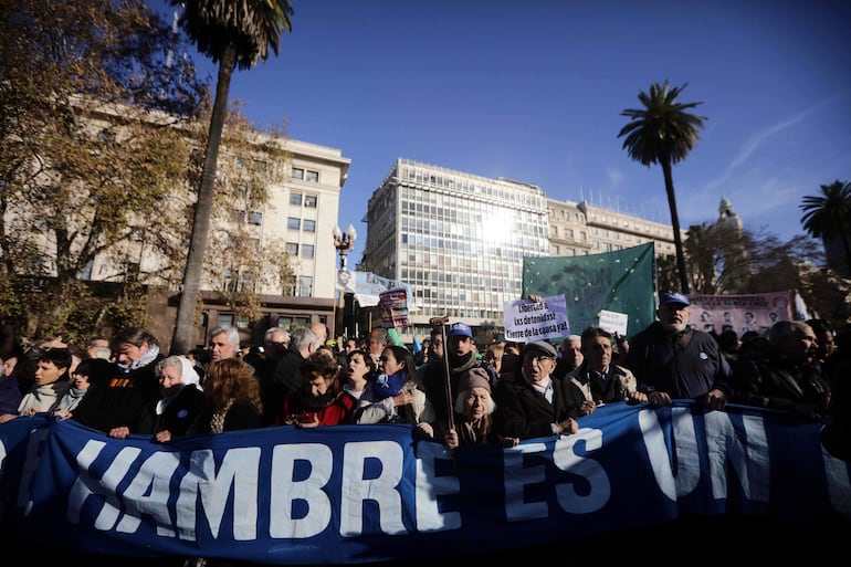 Miembros y simpatizantes de organizaciones de derechos humanos asisten a una manifestación contra los recortes impuestos por el gobierno y el despido de miles de trabajadores estatales en la Plaza de Mayo, en Buenos Aires.