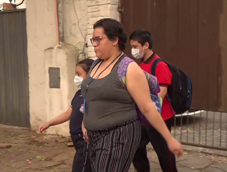 Una madre lleva a sus dos hijos estudiantes con tapabocas a la escuela, ante la baja calidad del aire por incendios forestales.