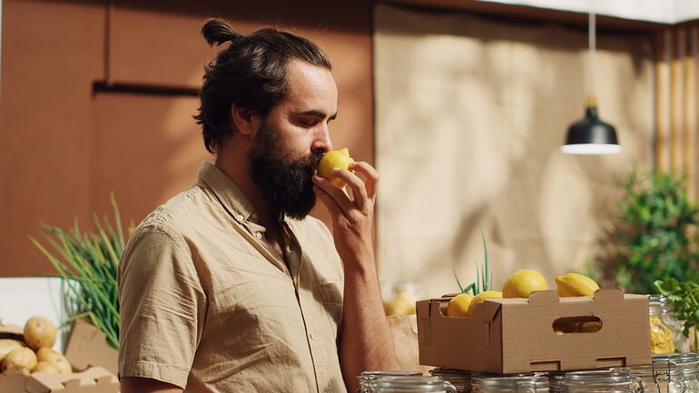 Hombre disfrutando del aroma de un limón de cultivo orgánico.
