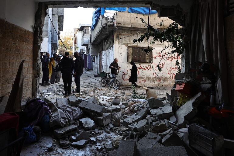 TOPSHOT - People inspect the damage following an overnight Israeli raid on the Tulkarm refugee camp in the occupied West Bank, on January 9, 2024, amid continuing battles between Israel and the Palestinian militant group Hamas in Gaza. (Photo by Zain JAAFAR / AFP)