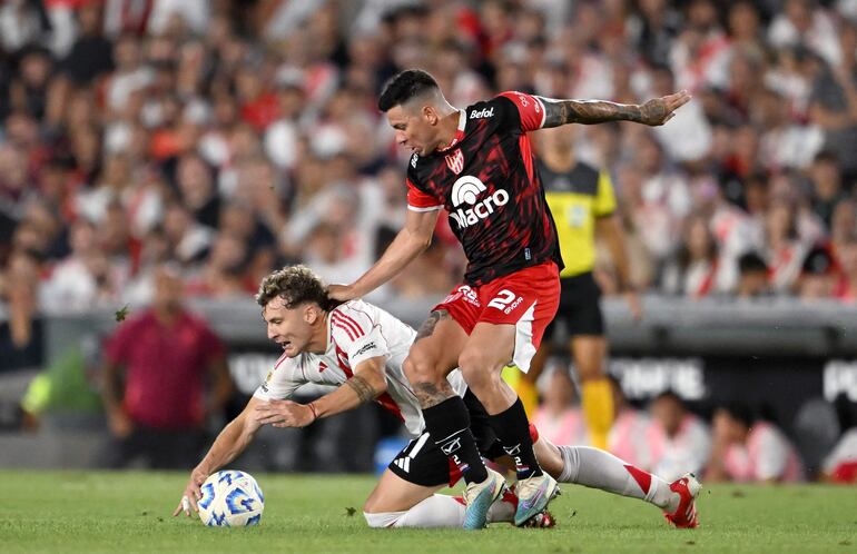 El paraguayo Juan Franco (d), zaguero de Instituto, disputa el balón con Facundo Colidio, delantero de River Plate.