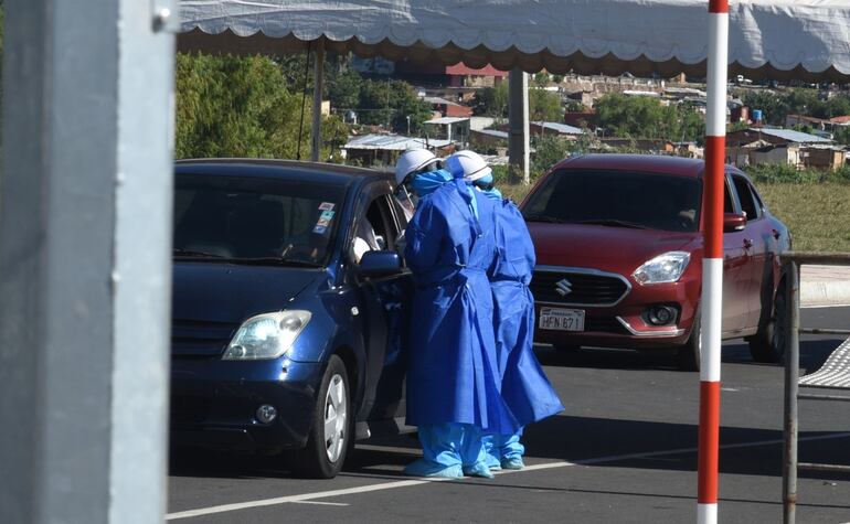 Sin bajarse del auto. Los automovilistas son testeados en busca de coronavirus por personal sanitario ataviado con ropas de protección.