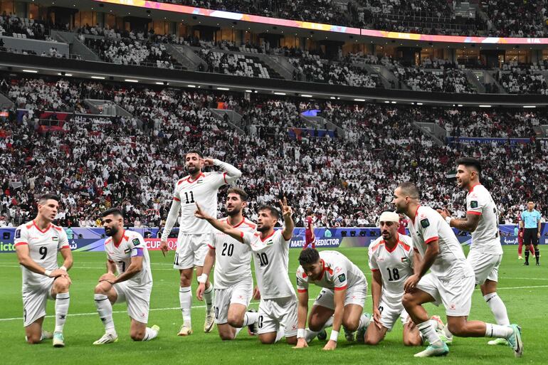 Los jugadores de Palestina celebran marcar su primer gol durante el partido de fútbol de la Copa Asiática de la AFC Qatar 2023 entre Qatar y Palestina en el estadio Al-Bayt en al-Khor, al norte de Doha, el 29 de enero de 2024. (Fotoby Hector RETAMAL / AFP)