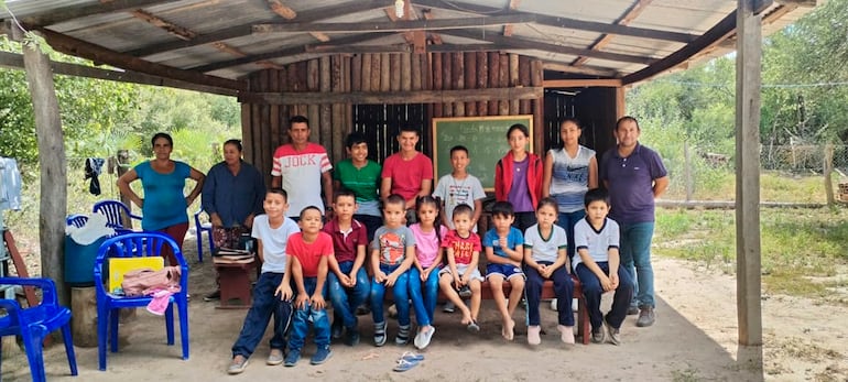 El maestro con sus alumnos y algunos padres que ayudan en el local de la capilla donde se desarrollan las clases, en medio de numerosas carencias.