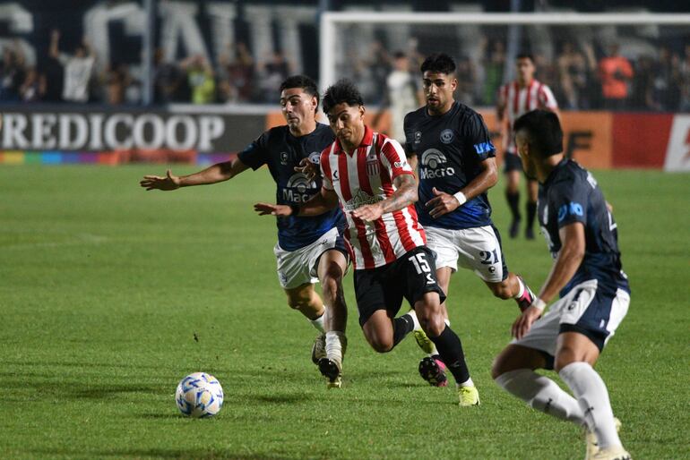 Santiago Arzamendia (c), de Estudiantes de La Plata, enfrenta la marca de tres jugadores de Independiente Rivadavia