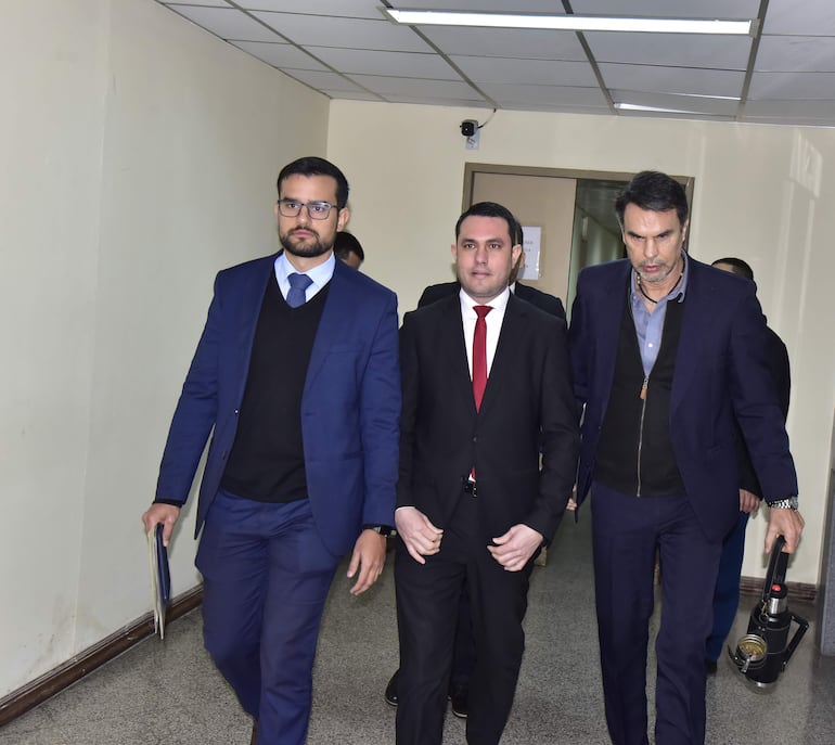 El senador ciolorado cartista Hernan David Rivas (c.) en tribunales, con sus abogados Álvaro Cáceres (izq.) y Cristóbal  Cáceres Frutos, tras su audiencia deimposición de medidas.