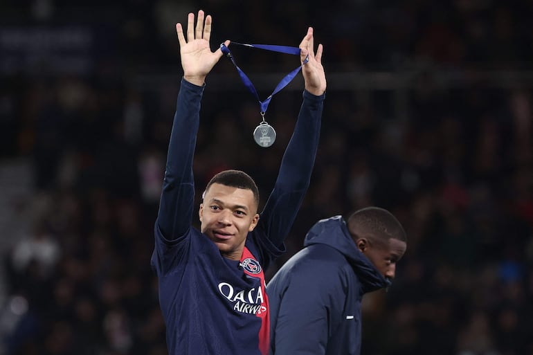 El delantero francés número 07 del Paris Saint-Germain, Kylian Mbappé, celebra con su medalla tras ganar el partido de fútbol del Trofeo de Campeones de Francia (Trophee des Champions) entre el Paris Saint-Germain (PSG) y el Toulouse FC en el estadio Parc des Princes, en París, el 3 de enero. , 2024.
