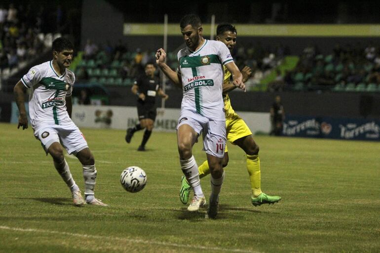 El ñuense Juan Barrios intenta salir jugando ante Blas Medina, el lateral Yony Villazanti, observa la acción. (Foto: APF)