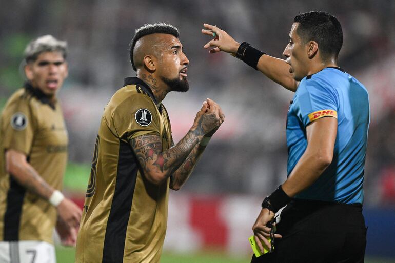 El chileno Arturo Vidal (i), jugador de Colo Colo, reclama al árbitro en un partido frente a Alianza Lima por la fase de grupos de la Copa Libertadores 2024 en el estadio Alejandro Villanueva, en Lima, Perú.